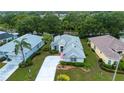 Aerial view of a single-story home with lush landscaping, a long driveway, and mature trees at 2121 Worthington Greens Dr, Sun City Center, FL 33573