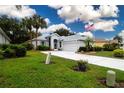 Well-maintained single-story home with a manicured lawn, elegant landscaping, and a long driveway at 2121 Worthington Greens Dr, Sun City Center, FL 33573