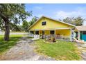 Charming yellow home featuring a cozy porch and well-maintained lawn at 2174 62Nd N St, Clearwater, FL 33760