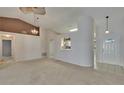Open-concept living area with neutral carpet, high ceilings, and decorative lighting fixtures at 2527 Wrencrest Cir, Valrico, FL 33594