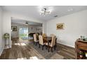 Inviting dining area with wood-look flooring, modern lighting, and stylish decor adjacent to the living room at 32718 Harmony Oaks Dr, Wesley Chapel, FL 33545