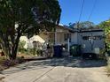 Single story home's front view featuring a small porch and front yard with an array of items at 3311 W Saint Conrad St, Tampa, FL 33607