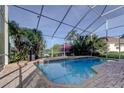 Inviting screened-in pool area features a brick patio and lush tropical foliage at 3322 Cypress Landing Dr, Valrico, FL 33596