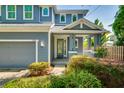 Close up view of a charming two-story home with a well-manicured lawn and mature landscaping at 3714 W San Juan St, Tampa, FL 33629