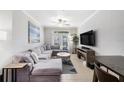 Living room with gray sectional sofa, tile floors, ceiling fan, and view of outdoor patio at 4221 W Spruce St # 2104, Tampa, FL 33607