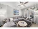 Bright living room featuring a gray sectional sofa, ceiling fan, and access to the outdoor patio at 4221 W Spruce St # 2104, Tampa, FL 33607