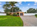 Well-maintained single-story home with a brick driveway, mature landscaping, and privacy fence at 4400 Helena Ne St, St Petersburg, FL 33703