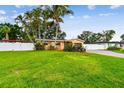 Expansive green lawn and lush landscaping surrounding a cozy single-story home with privacy fence at 4400 Helena Ne St, St Petersburg, FL 33703