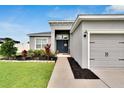 Inviting entryway with lush landscaping leading to the front door and garage at 4435 Devinshire Fields Loop, Plant City, FL 33567