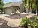 Inviting walkway with lush garden leading to home's entrance, featuring a beautiful fountain at 4808 Jewell Ter, Palm Harbor, FL 34685
