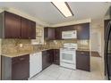 The kitchen features granite countertops, white appliances, and dark wood cabinets at 4842 Odyssey Ave, Holiday, FL 34690