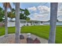 Landscaped front yard with manicured lawn, decorative rocks, and palm trees framing the freshly painted single-story home at 513 Fairhope Dr, Apollo Beach, FL 33572