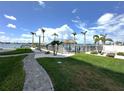 Tranquil outdoor pool area with lounge chairs, tiki huts and palm trees overlooking the water at 5220 Brittany S Dr # 1306, St Petersburg, FL 33715