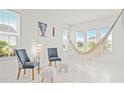 Bright living room with lots of natural light, a hammock, plush decor, and clean tile floors at 5810 Fieldmoor Ct, Palmetto, FL 34221
