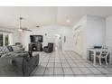 Spacious living room with white walls, tile flooring, and a modern ceiling fan at 7330 Fairwood Ave, New Port Richey, FL 34653