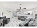Bright living room with tile floors, ceiling fan, and comfortable gray seating at 7330 Fairwood Ave, New Port Richey, FL 34653