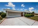 Angle shot of a home showing the driveway, screened garage, and brick exterior at 801 Oakmont Ave, Sun City Center, FL 33573