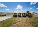 Well-kept single-Gathering home with charming landscaping and screened garage under a bright, blue sky at 801 Oakmont Ave, Sun City Center, FL 33573