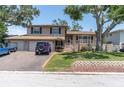 Charming two-story home featuring a brick facade, a two-car garage, and a cozy front porch at 8263 132Nd St, Seminole, FL 33776