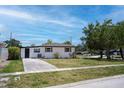Cozy single-story home with a spacious lawn, a painted driveway, and a fenced-in backyard at 9097 Southern Comfort Dr, Largo, FL 33773