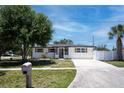 Inviting single-story home showcasing a lush lawn, long driveway, and freshly painted exterior at 9097 Southern Comfort Dr, Largo, FL 33773