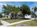 Attractive single-story home with lush landscaping, a green lawn, and a painted driveway at 9097 Southern Comfort Dr, Largo, FL 33773