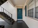 Welcoming condo entrance featuring a teal door, gray stairs, and a sidelight window at 10356 Carrollwood Ln # 204, Tampa, FL 33618