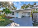 Cozy home featuring a covered parking area, light blue front door, and a well maintained front lawn at 10664 Starkey Rd, Seminole, FL 33777