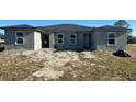 New construction duplex with a grey exterior, new roof, and partially landscaped yard at 13009 Ridgely Cir, Port Charlotte, FL 33981