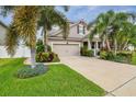 Inviting two-story home boasting tropical landscaping, mature palms, and a well-kept lawn at 13118 Rain Lily Dr, Riverview, FL 33579