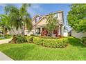Well maintained two-story home with colorful landscaping and green lawn under a bright blue sky at 13118 Rain Lily Dr, Riverview, FL 33579