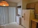 The kitchen features a stacked washer and dryer and a refrigerator ready to be stocked with your favorites at 1371 Pine Ridge E Cir # B8, Tarpon Springs, FL 34688