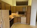 The kitchen features wood cabinets, essential appliances, and a functional layout ready for culinary creations at 1371 Pine Ridge E Cir # B8, Tarpon Springs, FL 34688