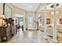 Spacious foyer with tile floors, ornate console table, and decorative columns providing a grand entrance at 15135 Azra Dr, Odessa, FL 33556