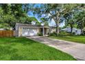 Inviting single-story home with a long driveway leading to a garage and a well-maintained front lawn at 1524 Essex N Dr, St Petersburg, FL 33710