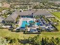 Aerial view of the luxurious community clubhouse featuring pools, cabanas, and manicured grounds at 15528 Corona Del Mar Dr, Wimauma, FL 33598
