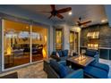Covered outdoor living space with comfortable seating, outdoor kitchen, ceiling fans, and seamless access to indoor living at 1617 El Pardo Dr, Trinity, FL 34655