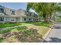 Well-maintained townhouses with green lawns, lush trees, and sidewalks at 1710 Belleair Forest Dr # A, Belleair, FL 33756