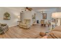 Inviting living room featuring wood-look floors, ceiling fan, and neutral decor at 1710 Belleair Forest Dr # A, Belleair, FL 33756