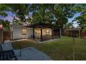 Backyard featuring outdoor kitchen and bar area under a pergola, perfect for entertaining at 1851 Oklahoma Ne Ave, St Petersburg, FL 33703