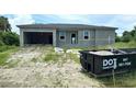 Unfinished house with a visible gray exterior, window frames, and a dumpster at 18581 Lake Worth Blvd, Port Charlotte, FL 33948