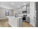 Bright kitchen with gray cabinets, stainless steel appliances, center island, tile backsplash, and modern fixtures at 2426 Hiers Rd, Dover, FL 33527