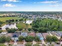 Expansive aerial view showcasing the neighborhood, nearby lakes, lush greenery, and community amenities at 3230 Bellericay Ln, Land O Lakes, FL 34638