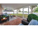 Relaxing screened-in back porch with stylish seating and view of the landscaped backyard at 3230 Bellericay Ln, Land O Lakes, FL 34638
