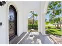 Covered porch with a dark arched front door and sitting area, ideal for welcoming guests at 3404 W Sevilla St, Tampa, FL 33629