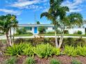 Landscaped front yard with a blue door single-story home on a sunny day at 3701 Manatee Se Dr, St Petersburg, FL 33705