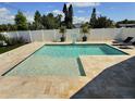 Inviting backyard pool with travertine deck, basketball hoop, and lounge chairs at 3701 Manatee Se Dr, St Petersburg, FL 33705