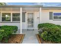 Inviting front porch with decorative pillars, a secure screen door, and neatly trimmed bushes enhancing curb appeal at 3818 Grove S St, St Petersburg, FL 33705