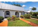 Charming home exterior with a metal roof, beautiful landscaping, and a walkway leading to the entrance at 4229 Glissade Dr, New Port Richey, FL 34652