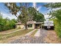 This inviting home has a carport, mature trees, a long driveway, and additional RV parking at 4411 W Bay Villa Ave, Tampa, FL 33611